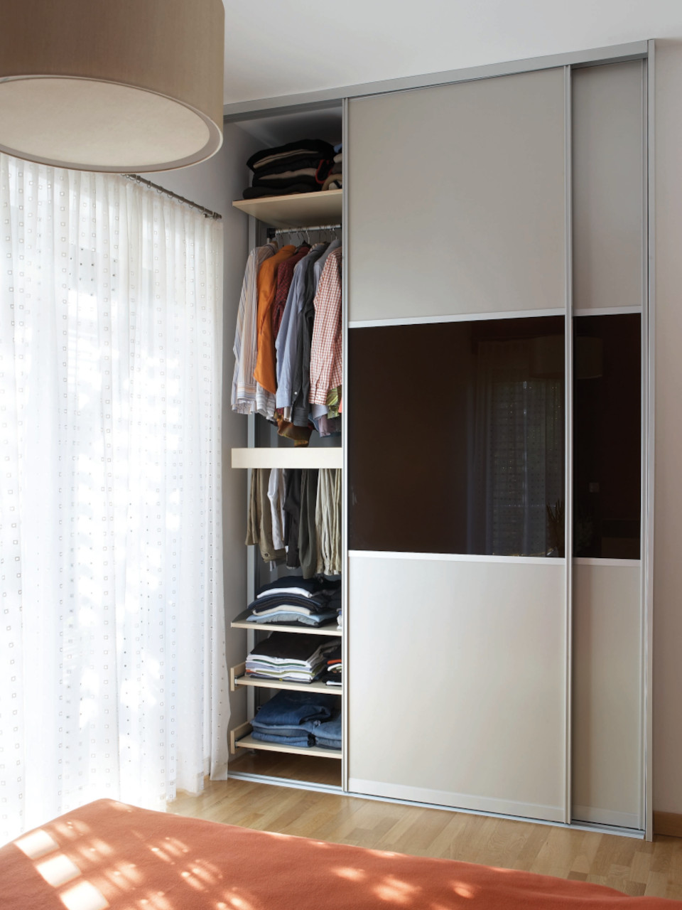 Modernes geschlossenes Schranksystem mit Schiebetüren im Schlafzimmer – platzsparende Lösung mit offenem Stauraum und stilvoller Front
