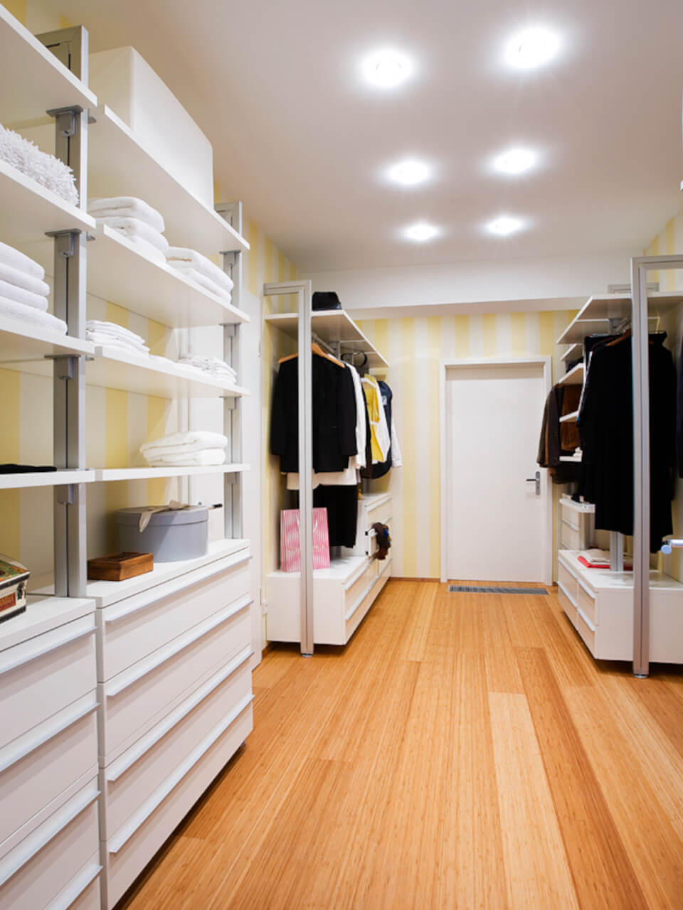 Individuell geplantes Schranksystem PREMIUM für begehbares Ankleidezimmer in weiß mit vielen Schubladen, Ablageflächen und Kleiderstangen mit unterschiedlichen Hängehöhen.