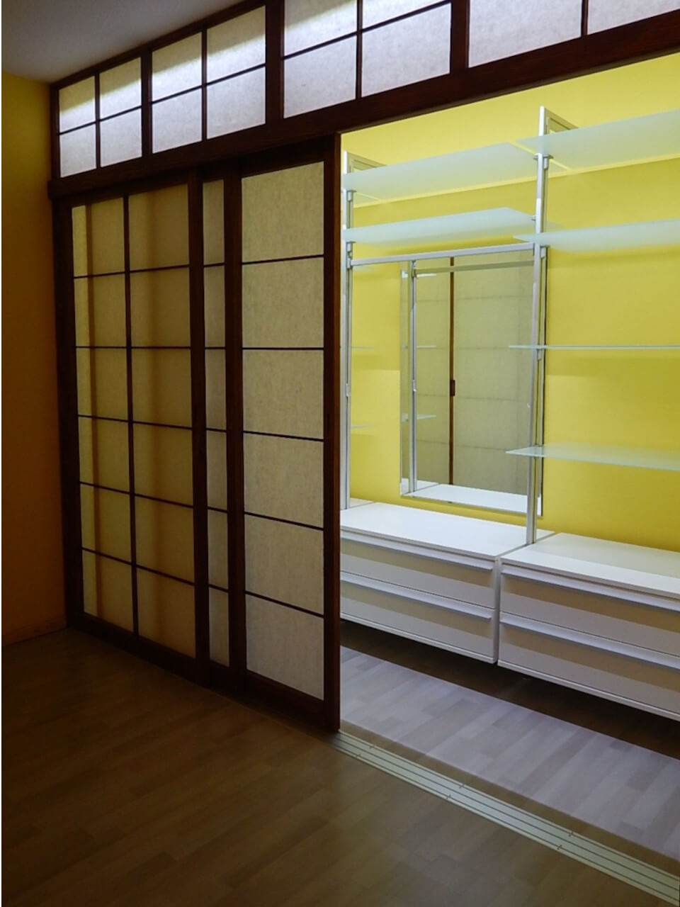 Offenes geschlossenes Schranksystem mit weißen Regalen hinter japanisch inspirierter Schiebetür – stilvolle Lösung für moderne Innenräume