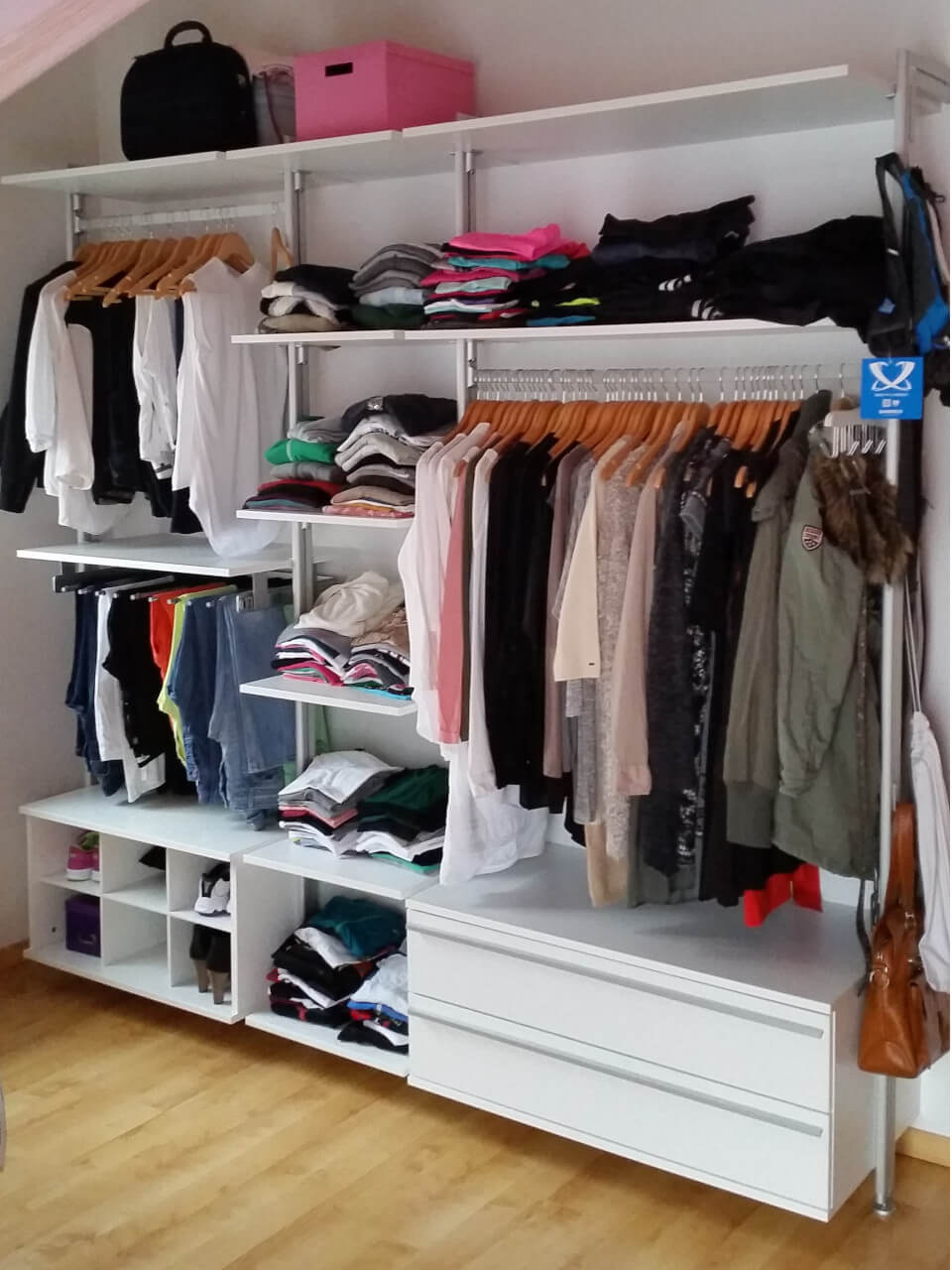 Offener Kleiderschrank in Weiß mit Fächern, Kleiderstangen und Schubladen in einem modernen Schlafzimmer